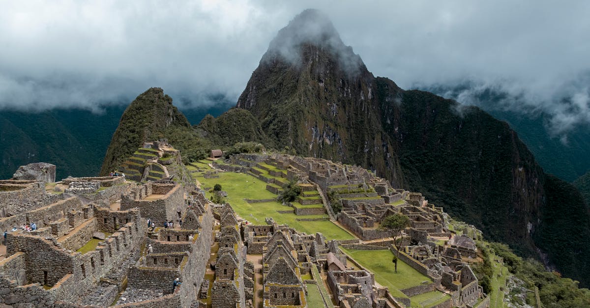 Explore the breathtaking ruins of Machu Picchu in Cuzco, Peru, surrounded by lush mountains and white clouds.