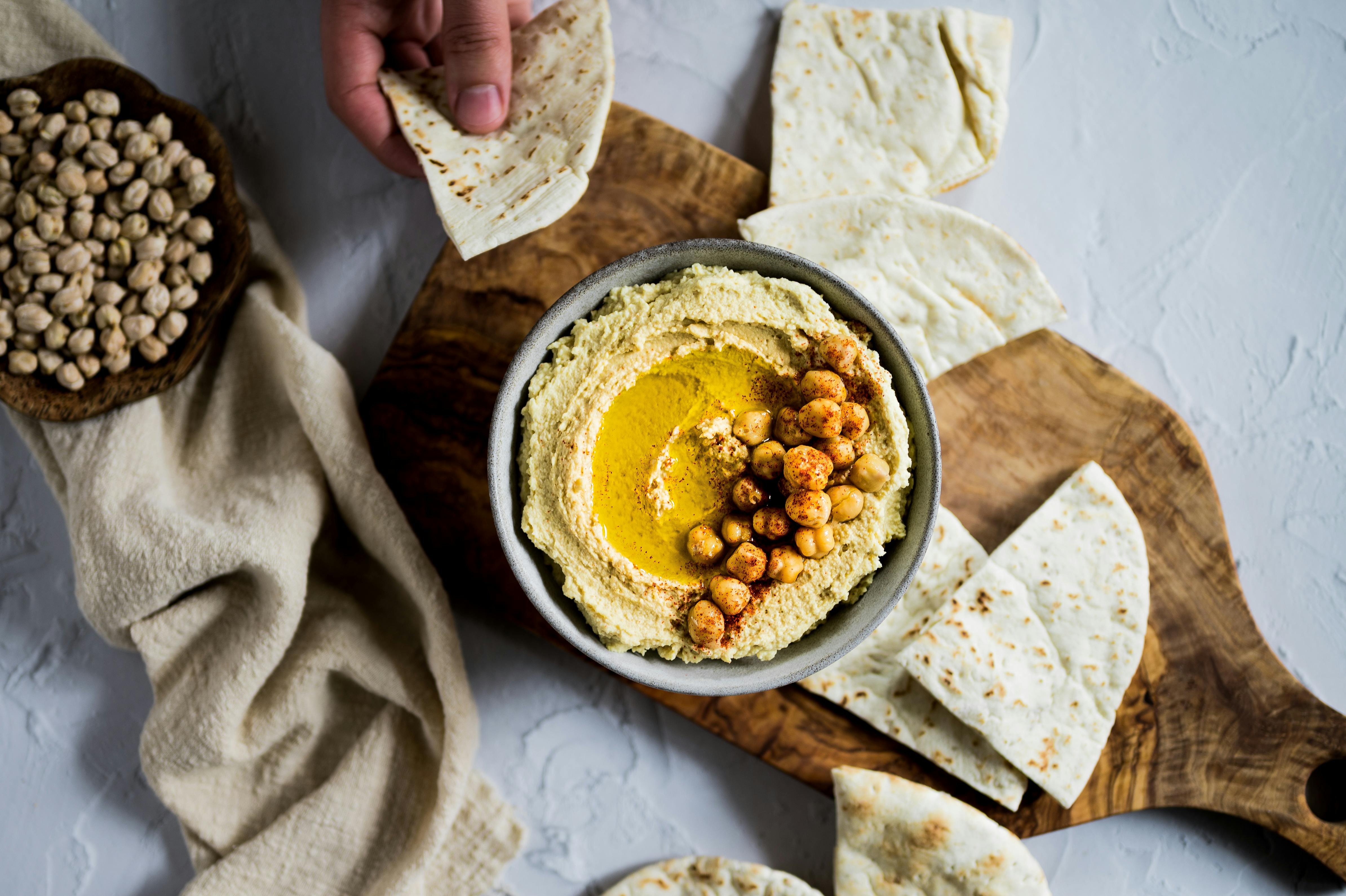 A Hummus on a Bowl Near the Pita Breads · Free Stock Photo