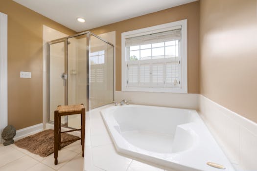 Bright and spacious modern bathroom with bathtub and glass shower enclosure.