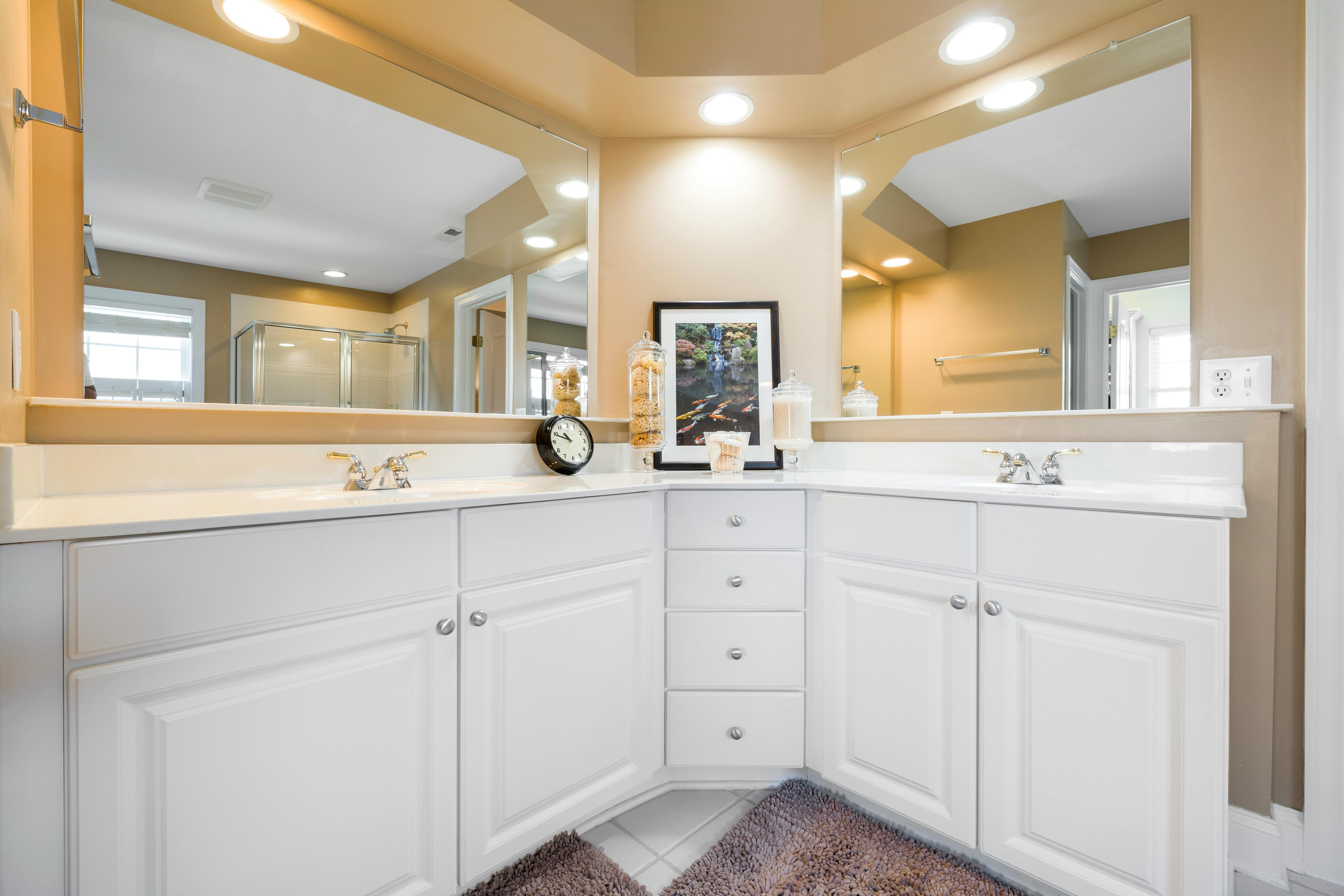 Free Bright and modern bathroom featuring a white vanity, dual mirrors, and elegant fixtures. Stock Photo