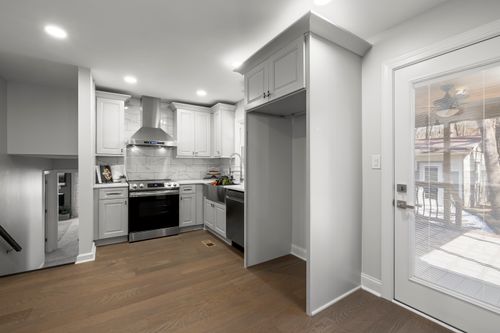 Free Bright minimalist kitchen with stainless steel appliances and wooden flooring. Stock Photo