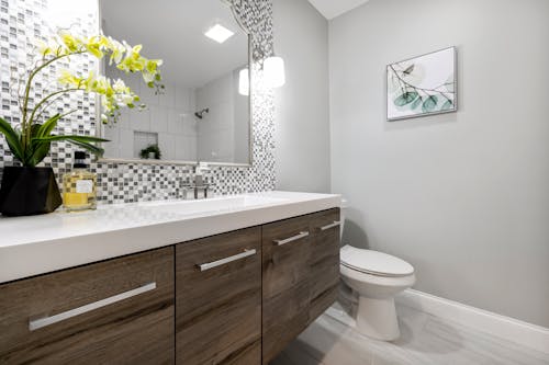 A Toilet Bowl Beside the White Ceramic Sink