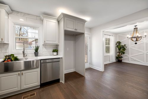 Free Bright modern kitchen featuring stainless steel sink and appliances with wooden flooring. Stock Photo