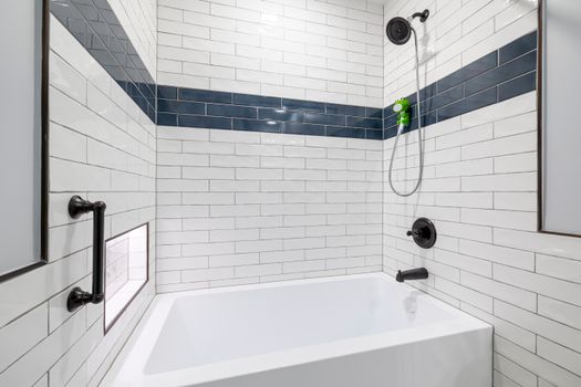 Sleek, minimalist bathroom with white and blue tiles and contemporary fixtures.