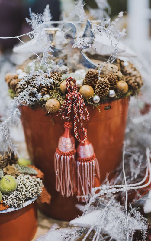 Free Close-up of a Christmas decoration arrangement featuring pine cones and ornaments in a red bucket. Stock Photo