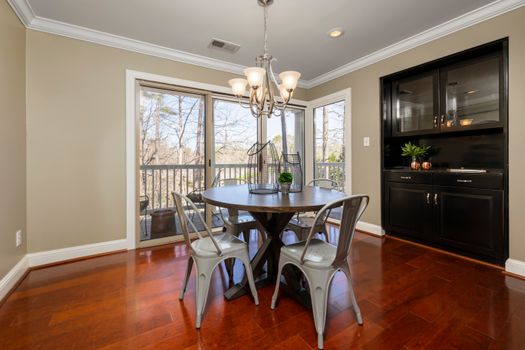 Elegant dining area with modern furniture and balcony view, perfect for gatherings.