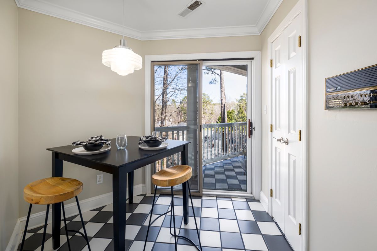 Chic dining nook featuring a black table, wooden stools, and a view to a balcony