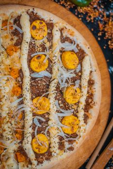 Delicious close-up of a gourmet pizza with cheese, sausage, and yellow tomato slices.