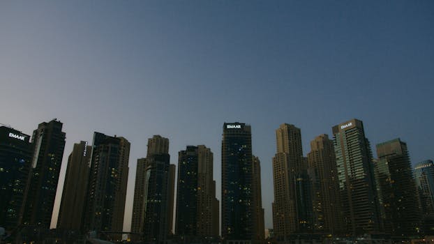Silhouette of modern skyscrapers against a twilight sky in an urban setting.