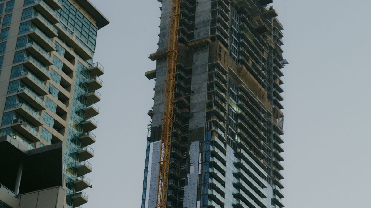 建設中の高層マンションを見上げた写真。太陽光には不動産のような空室リスクや入居者対応がない。