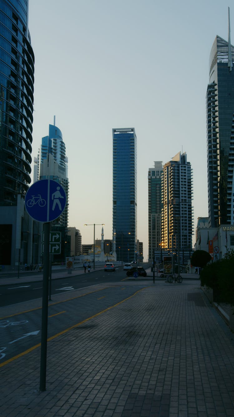 Photograph Of Buildings Near A Road Sign