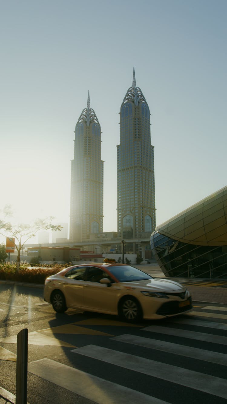 A White Sedan Car Near Al Kazim Towers In Dubai