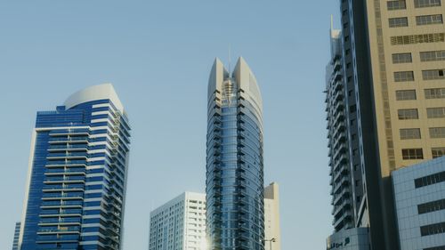 Free High-rise buildings in the Dubai skyline against a clear sky. Stock Photo
