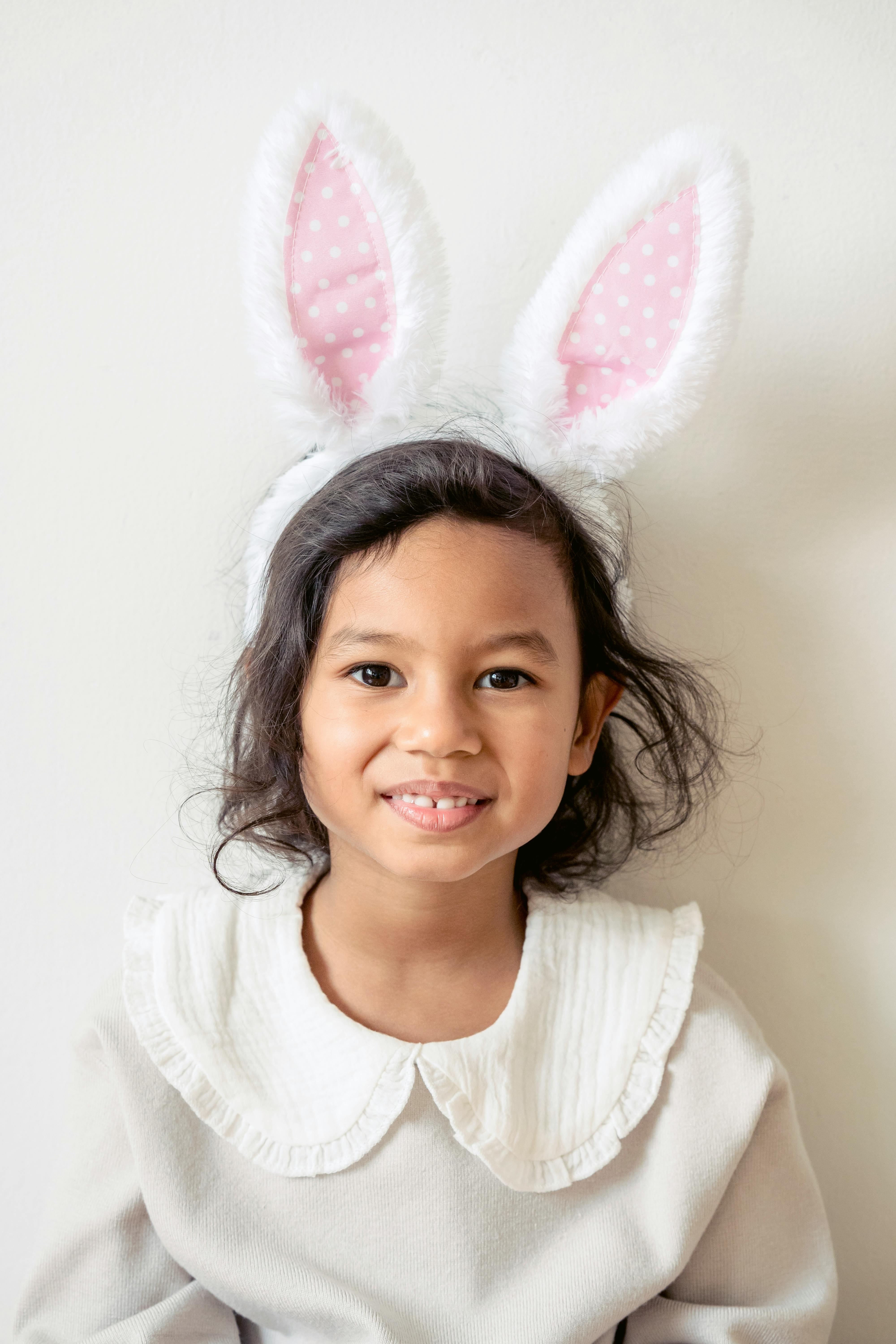 cute ethnic girl in bunny ears looking at camera