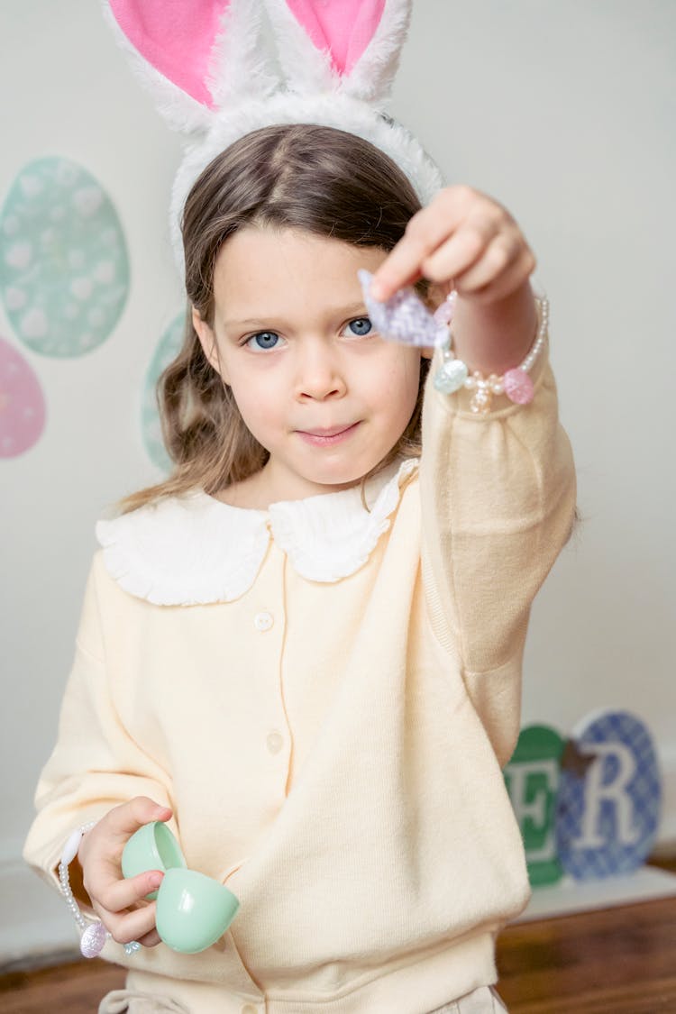 Adorable Kid Holding Candy And Plastic Egg During Easter Celebration