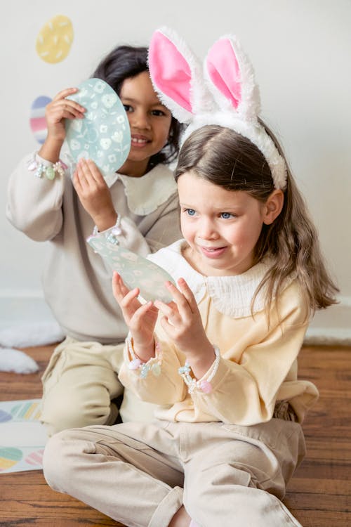 Joyful little multiethnic children decorating room for Easter holiday