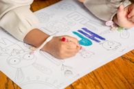 Girl drawing in coloring book in daylight