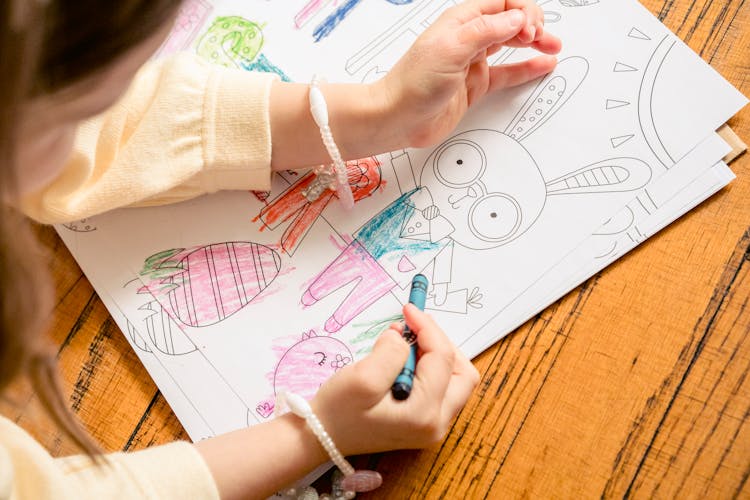 Girl Painting In Coloring Book In Daytime