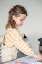Serious girl taking crayon for drawing picture