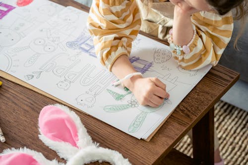Girl coloring greeting poster for Easter party