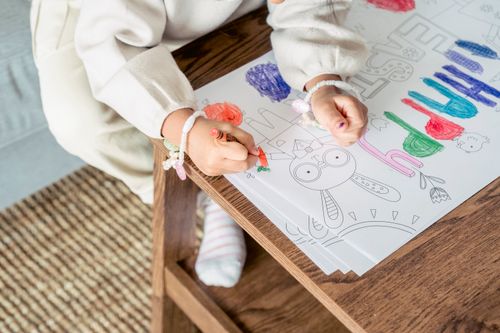 Free High angle of crop anonymous girl in bracelets painting picture with bright color for holy Easter Stock Photo