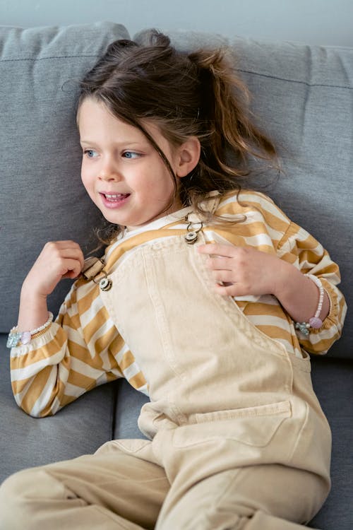 Free Cute little girl resting on sofa Stock Photo