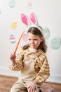 Confused girl wearing bunny ears with carrot in hand