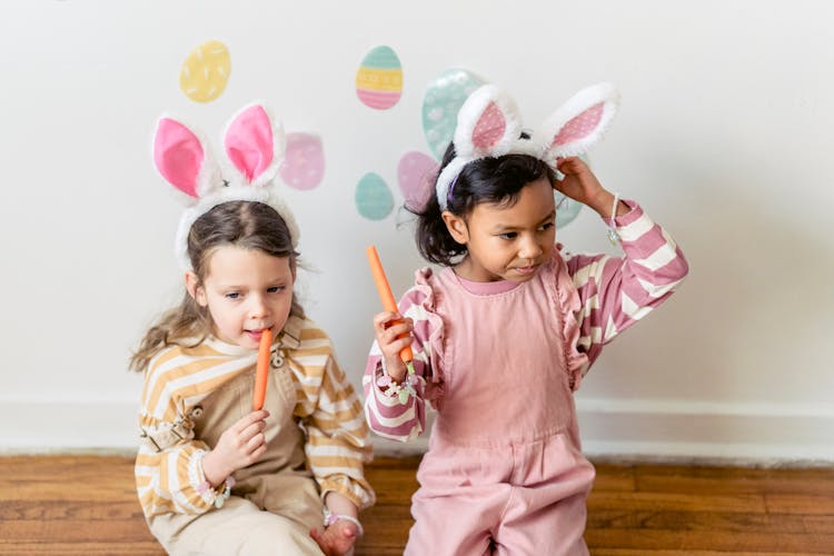 Girls Wearing A Bunny Ears While Eating Carrots