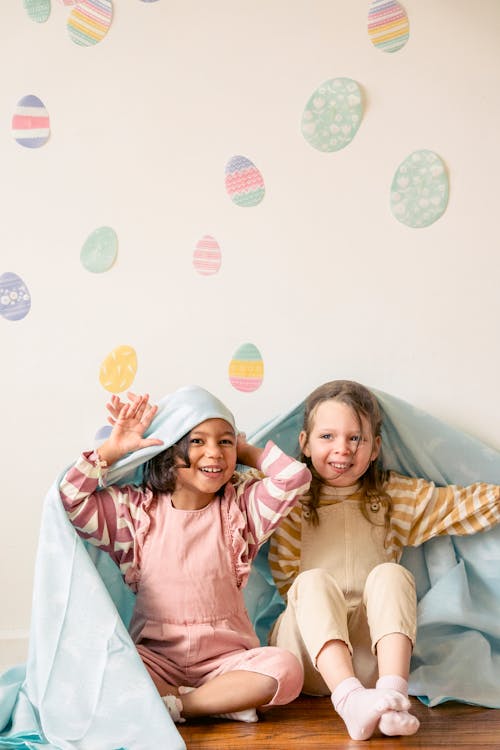 Free Kids Sitting on the Wooden Flooring while Hiding Under the Blanket Stock Photo