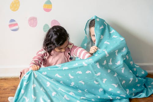 Free Two Girls Playing and Hiding in a Blanket Stock Photo