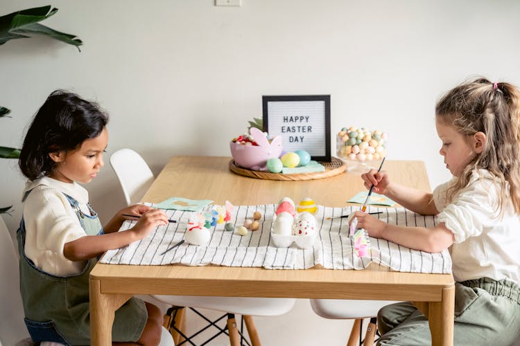 Girls Painting Eggs On Table