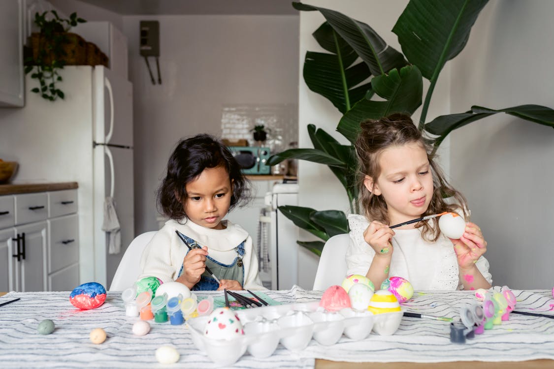 Diverse girls painting Easter eggs