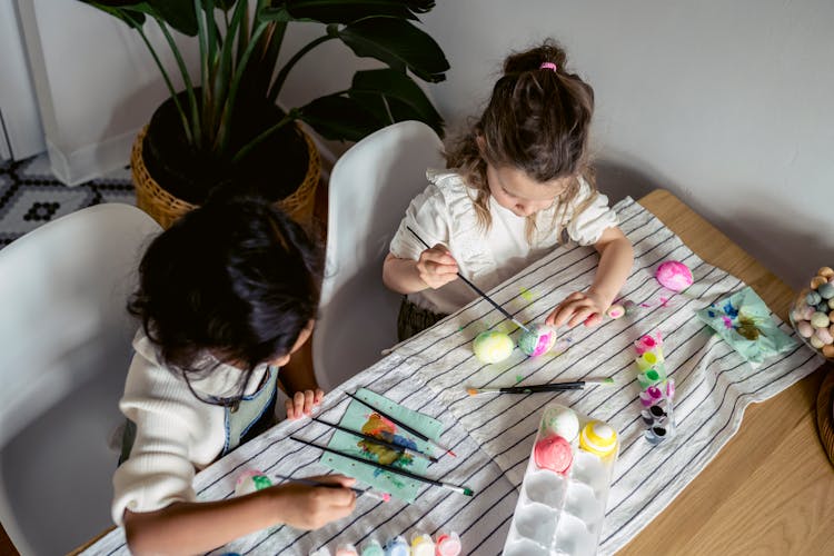 Girls Painting Eggs On The Table