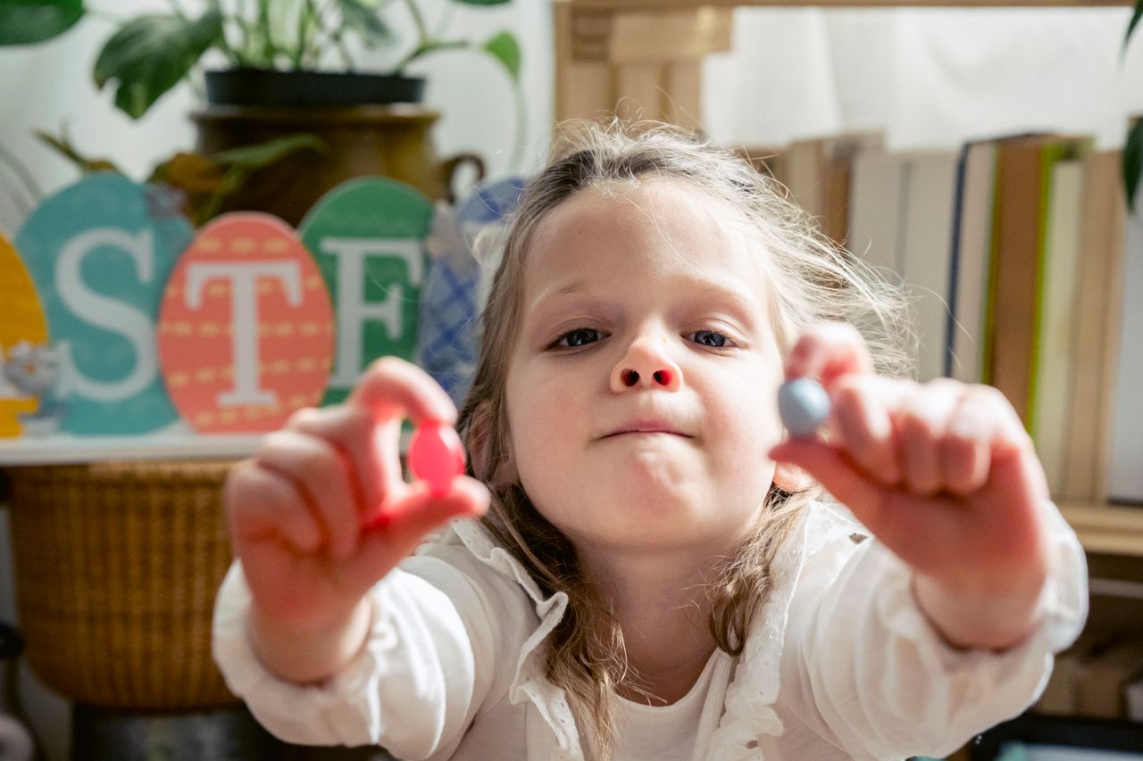 funny adorable small preschool girl looking at camera while demonstrat