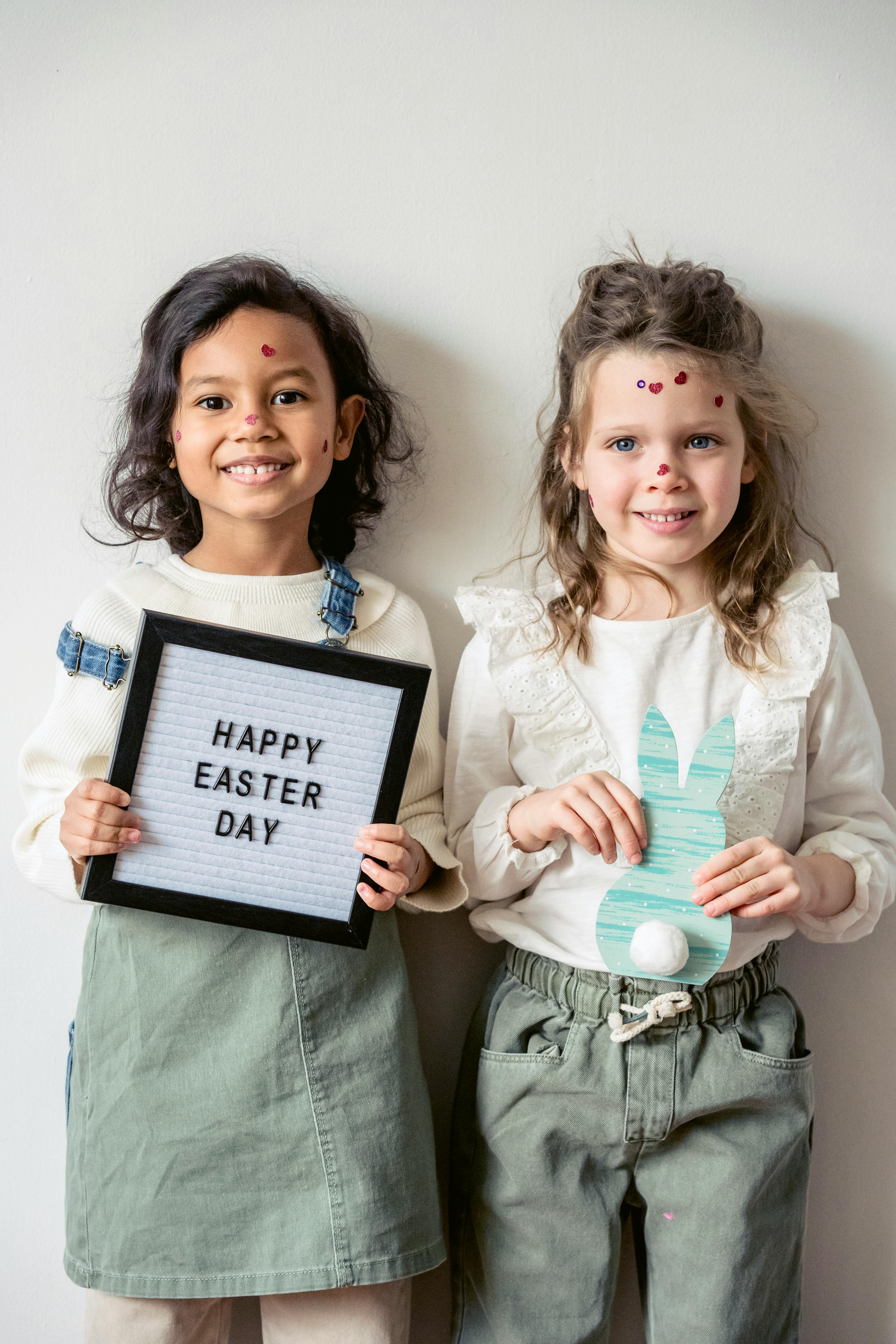 happy diverse girls with stickers on face and easter decorations