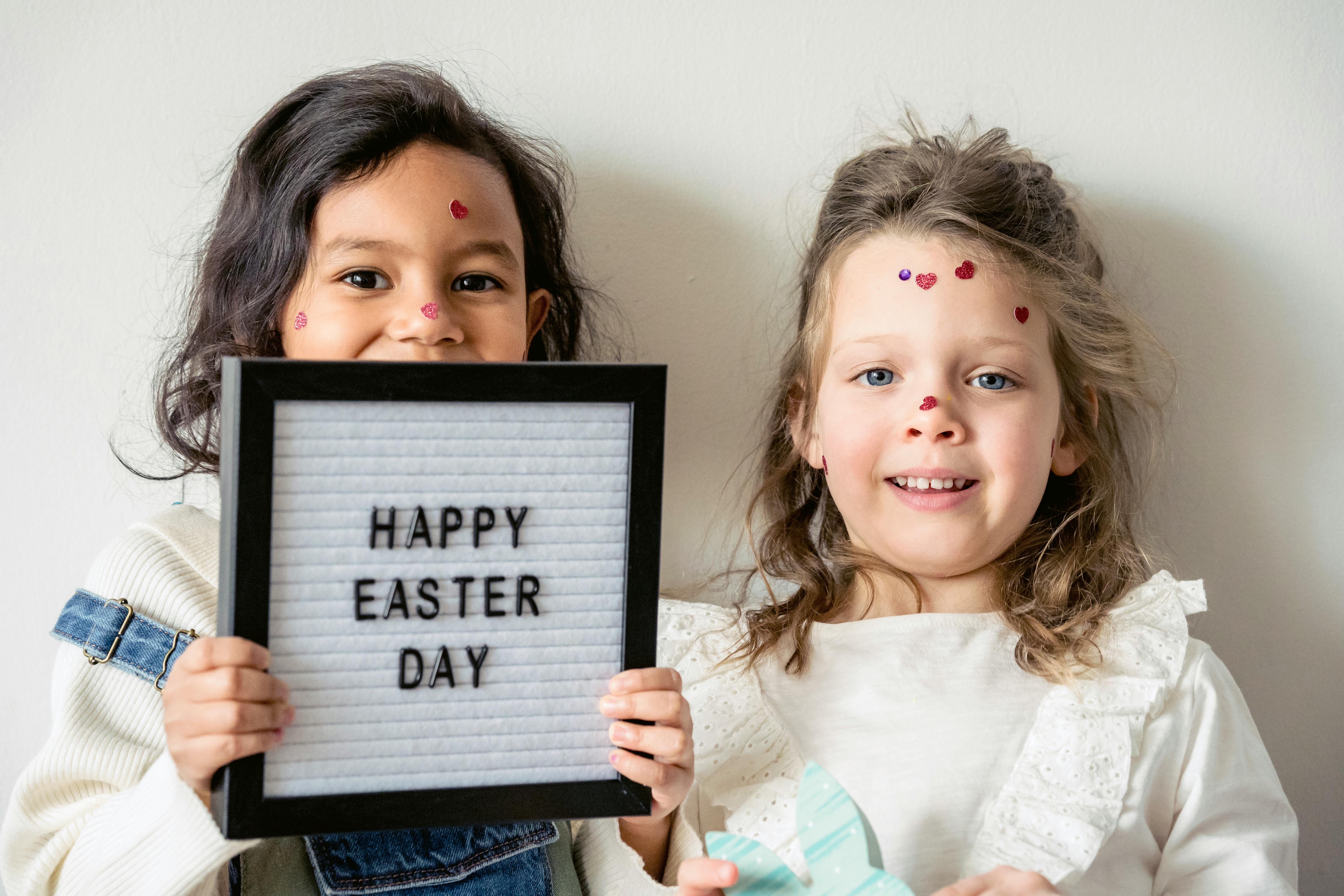 cheerful multiracial girls with signboard during easter holiday