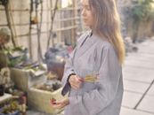Woman in Gray Coat Holding Brown Stick