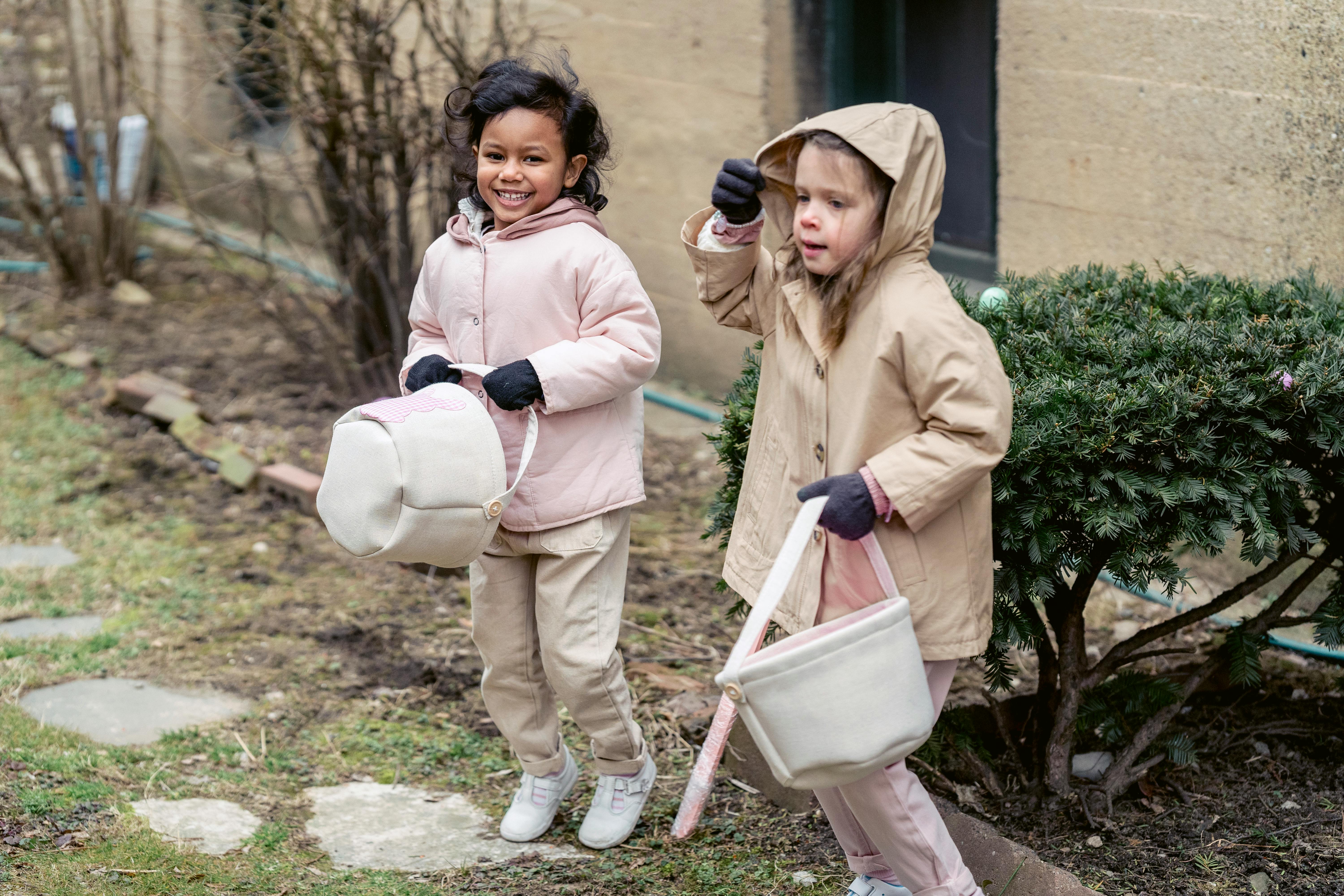 happy multiracial girls playing in backyard during easter holiday