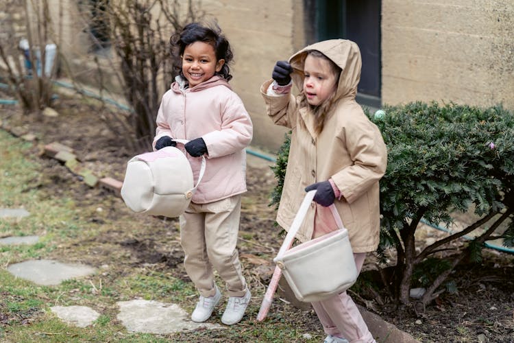 Happy Multiracial Girls Playing In Backyard During Easter Holiday