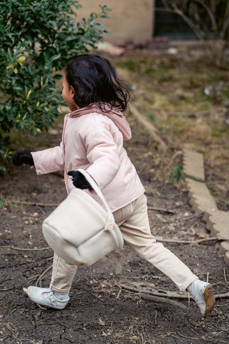 Faceless Girl With Soft Basket Walking In Autumn Garden