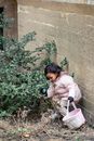 Content ethnic girl picking Easter egg in garden