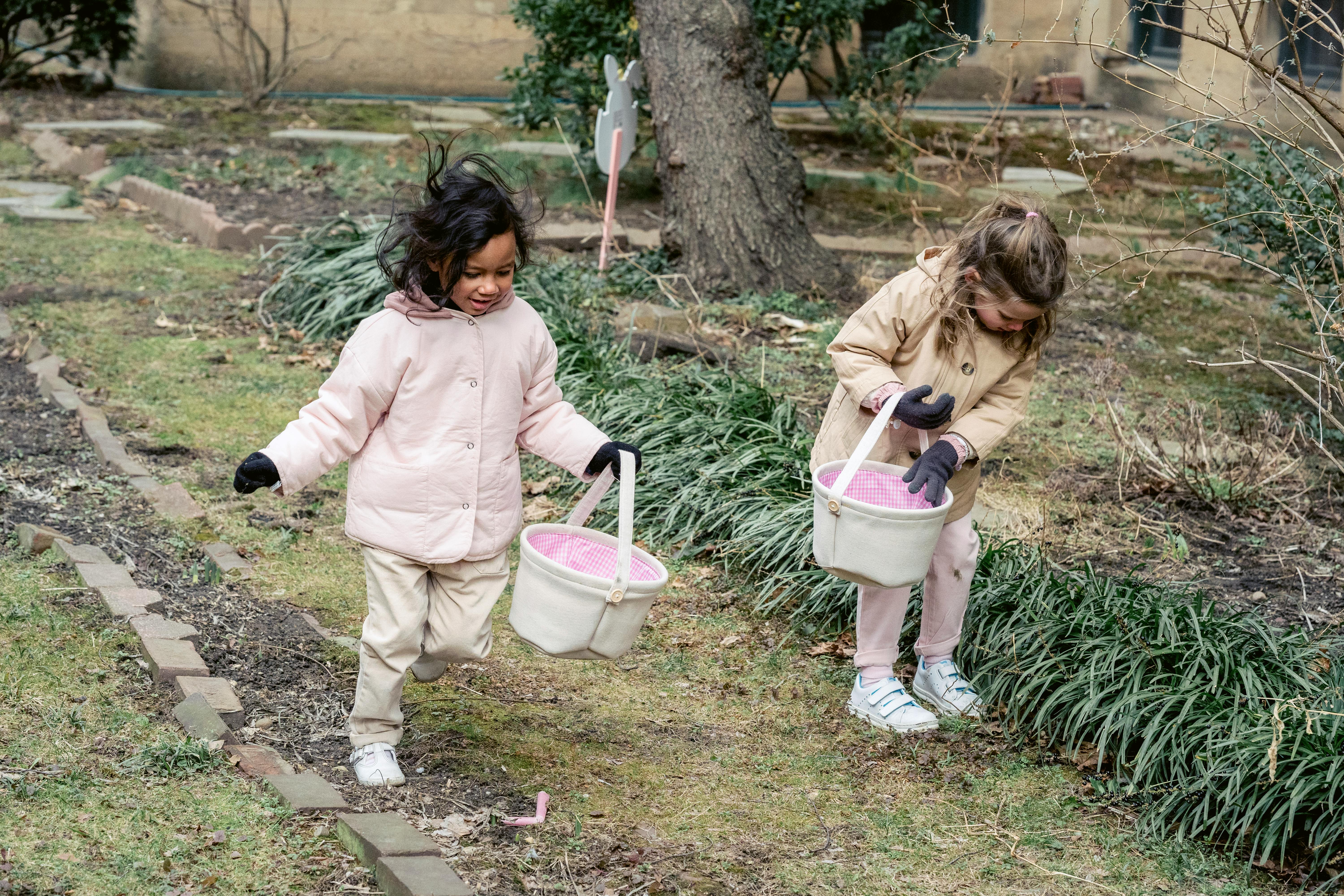 content diverse girls looking for easter eggs in garden