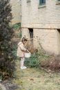 Girl with basket collecting Easter eggs in backyard