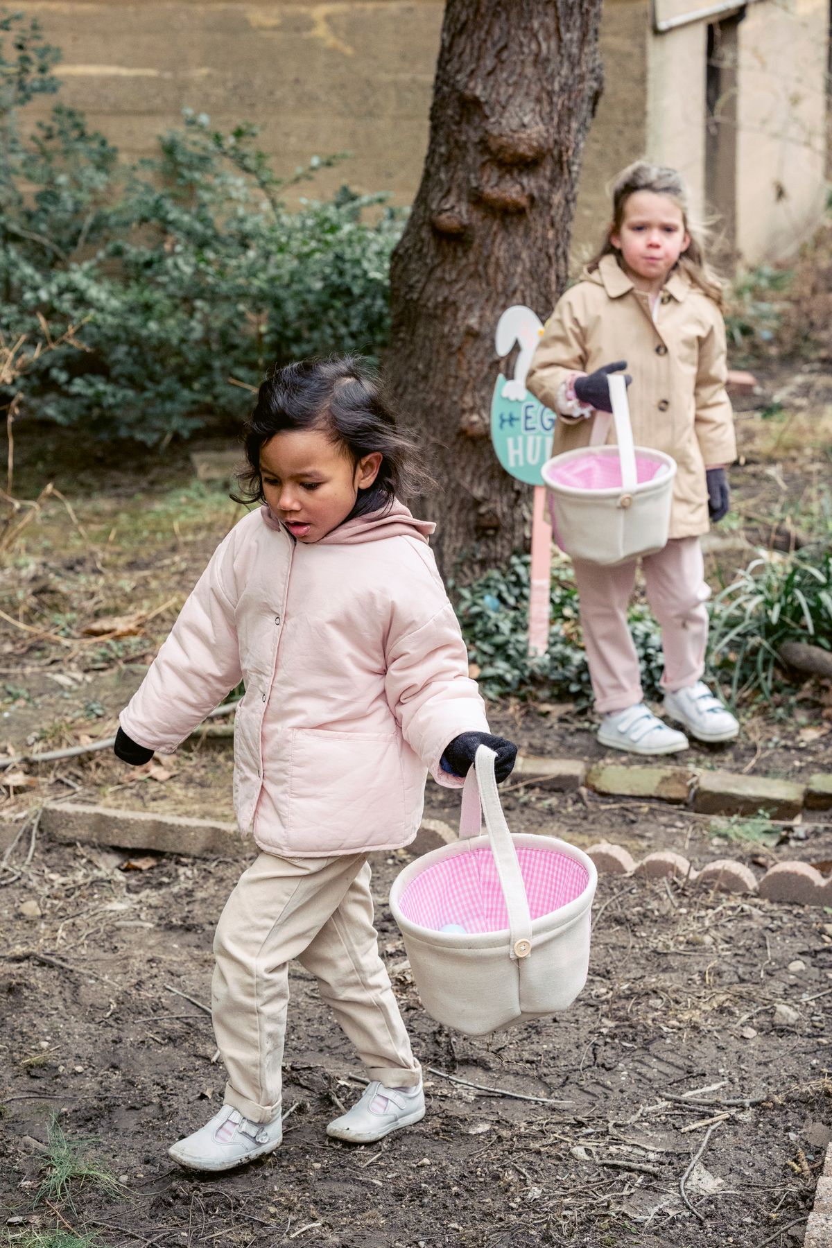 Children searching for hidden eggs with baskets, like a treasure hunt