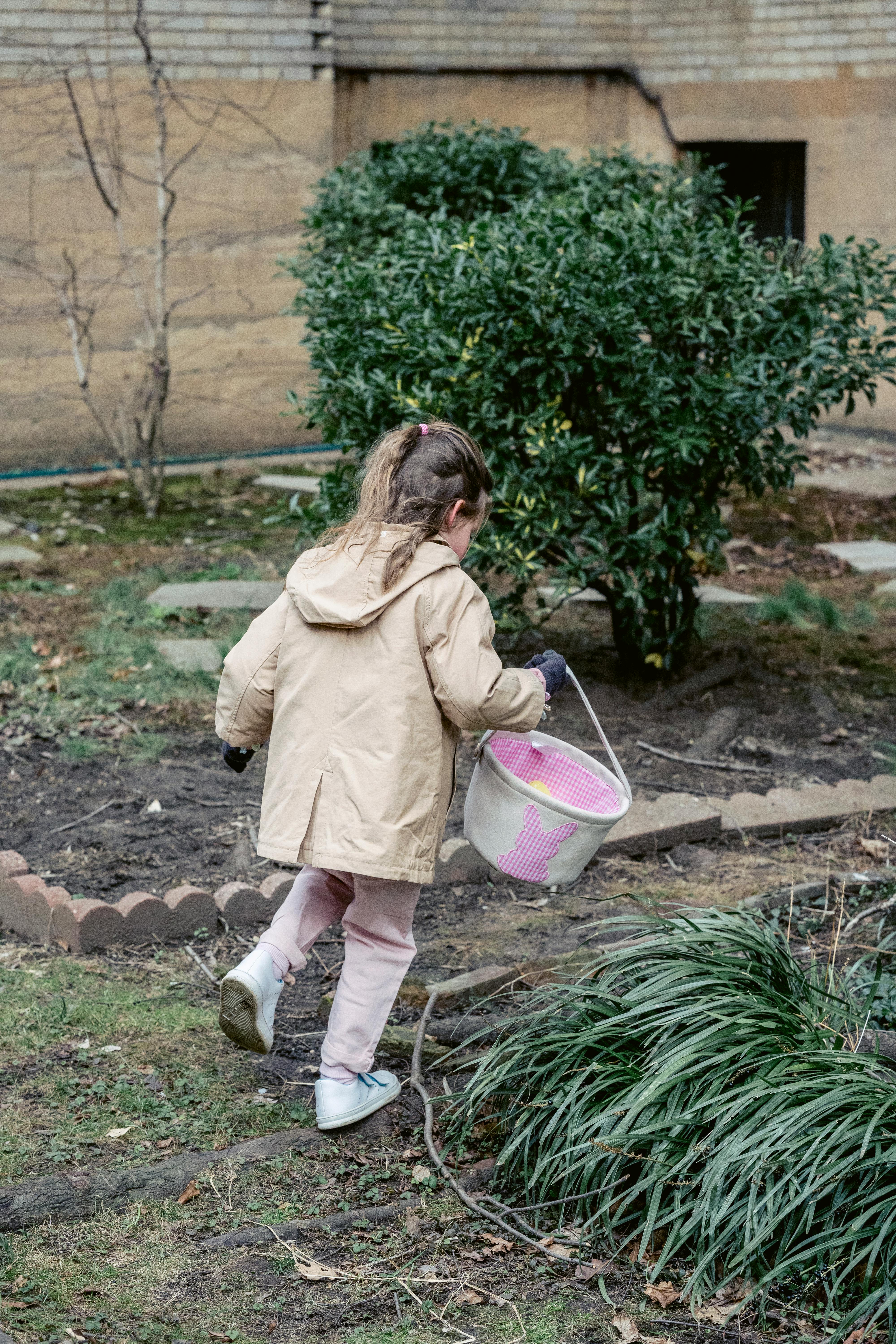 faceless girl collecting easter eggs in courtyard