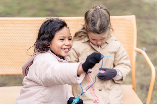 Cheerful multiethnic girls playing with soap bubbles in park