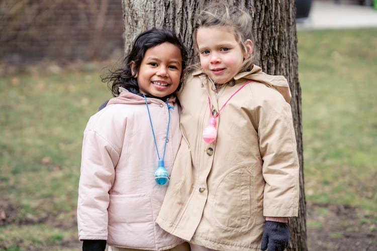 Girls In Brown And Pink Jacket Standing Beside Tree