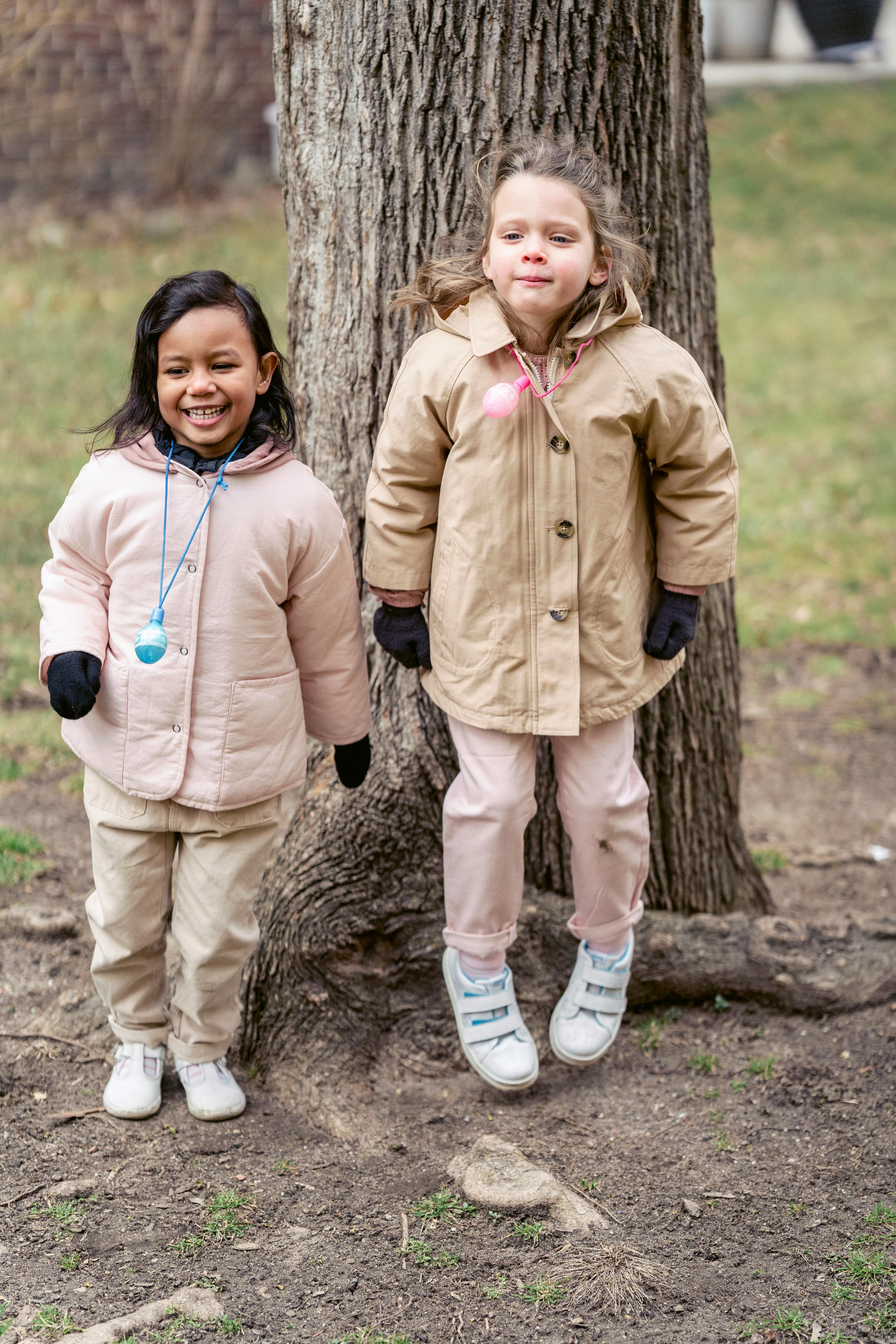 smiling diverse girlfriends on land in park