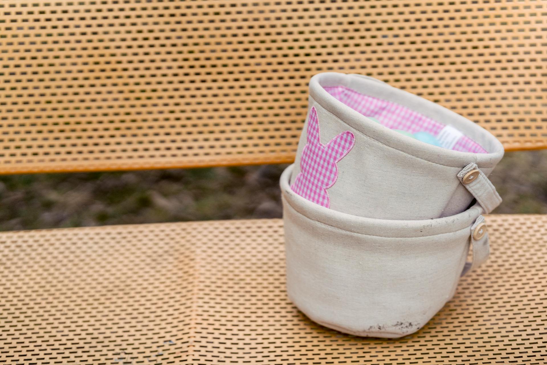 Textile baskets with checkered ornament on bunny symbol on bench during festive event in daytime