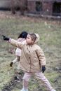 Girl pointing with finger against unrecognizable friend on lawn
